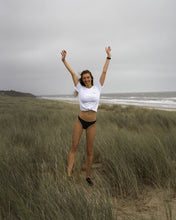 Load image into Gallery viewer, Ash Essential Organic Tshirt female model 2 on Irish beach
